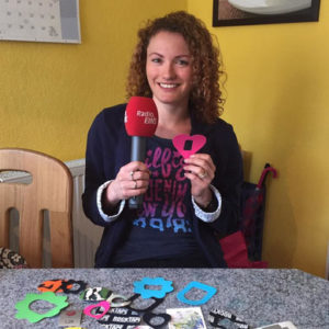 Sonja Spörlein mit Radio-EINS-Mikrofon und Zuckerschmuck-Stickern am Tisch